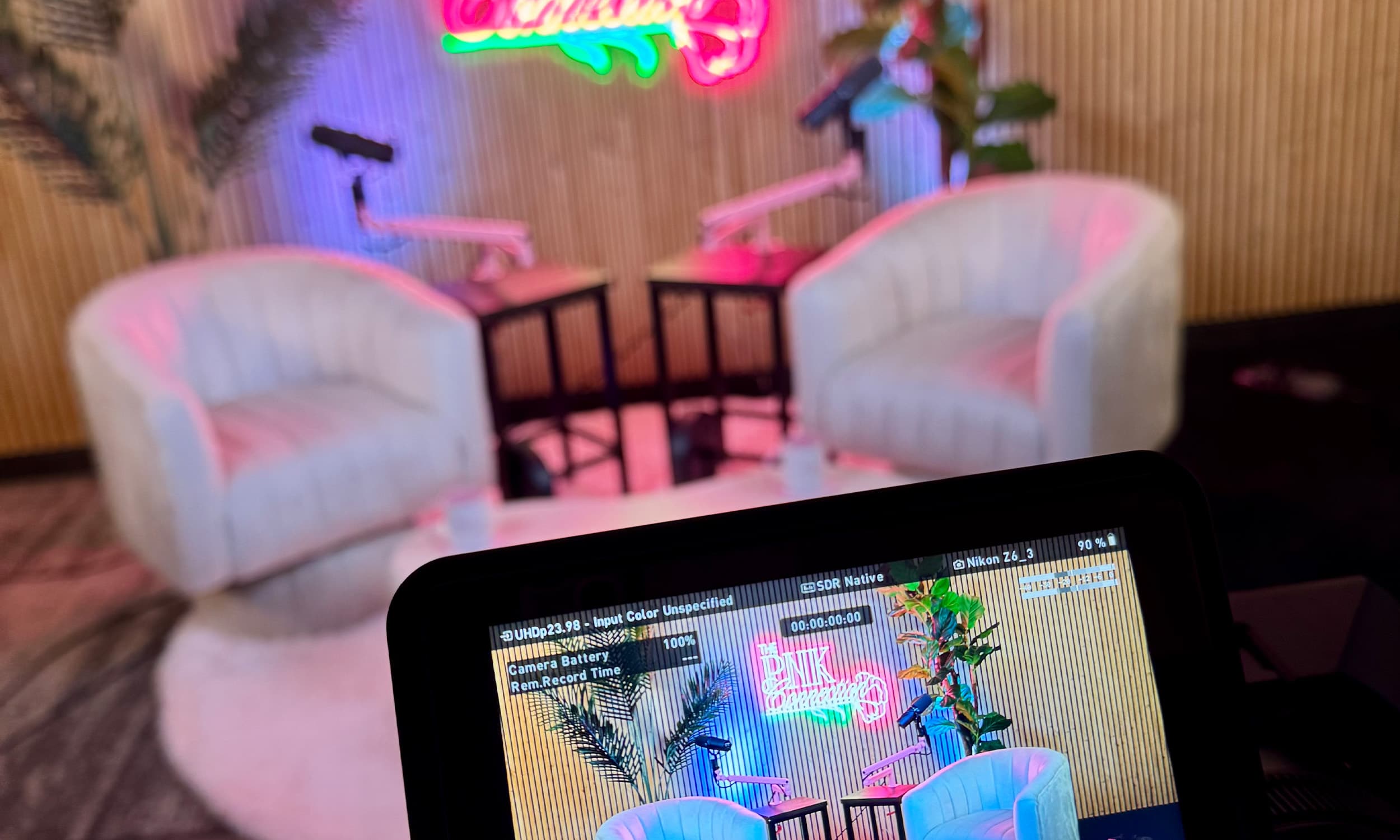 Custom studio set with designer chairs and neon signage